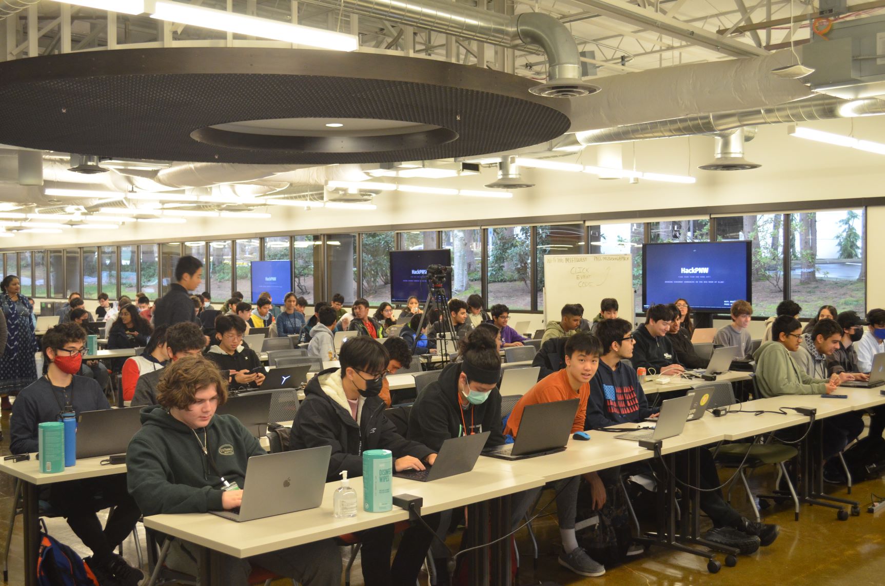 Photo of main event room with attendees sitting at their desk in front of their laptop