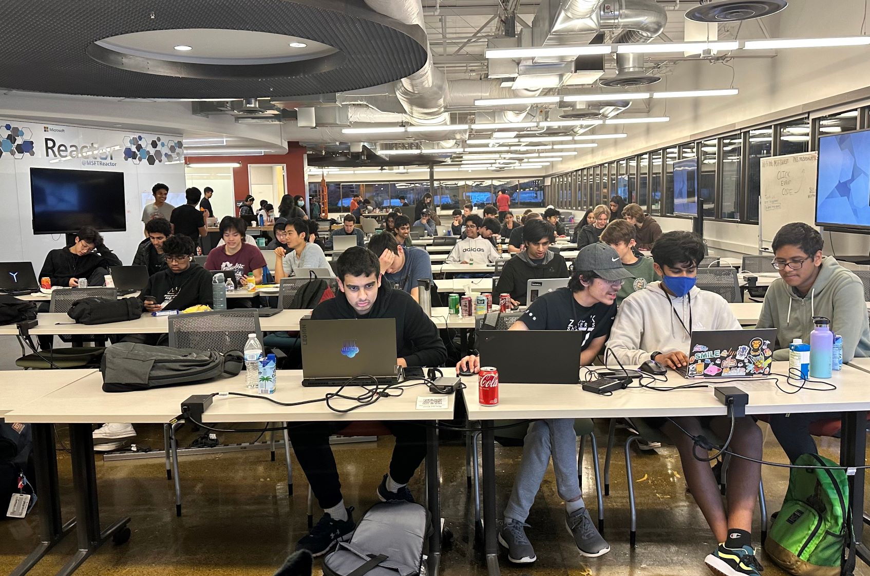 Photo of main event room with attendees sitting at their desk in front of their laptop